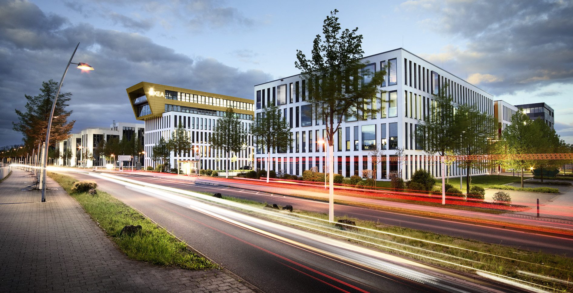 futuristische Bürogebäude mit Hauptstraße davor in Rheinufernähe in Monheim